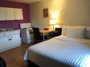 a bedroom with a bed and a kitchen with a table at Holiday House Motel in Ladysmith