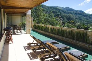 uma varanda com cadeiras e vista para uma montanha em Hotel Willisau em Teresópolis