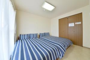 a bedroom with two beds and a wooden cabinet at Hakodate Stoke Hills in Hakodate