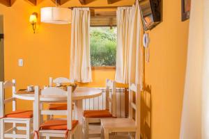 Un comedor con mesa y sillas y una ventana. en Cabañas Las Donosas, en San Carlos de Bariloche
