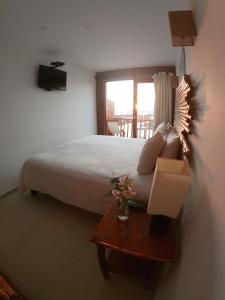 a bedroom with a bed and a table with a lamp at Bamboo Lodge Paracas in Paracas