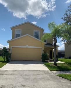 a large yellow house with a garage at Cozy Villa With South Facing Pool in Davenport