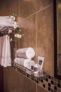 Baño con estante con toallas y espejo en Hotel Majova Inn Xalapa, en Xalapa