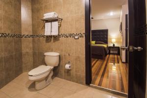 a bathroom with a toilet and a bed at Hotel Majova Inn Xalapa in Xalapa