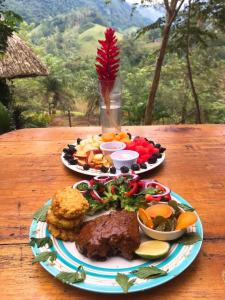 two plates of food sitting on a wooden table at Vista Verde Lodge in Lanquín