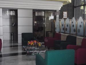 a waiting room with chairs and a table with flowers at Hotel Plaza Las Fuentes in Puebla