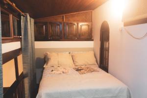 Cama en habitación con armarios de madera en Flat Bouganville, en Abraão