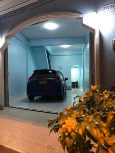 un'auto parcheggiata in un garage con riflesso di un'auto in uno specchio di Blue House Hat Yai a Hat Yai