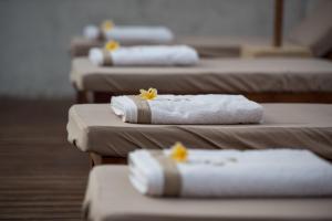 a row of beds with towels and flowers on them at Villa Luna Sunset Beach in Gili Trawangan