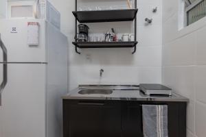 Una pequeña cocina con fregadero y refrigerador. en Cafofo Nice, en Río de Janeiro 26 fotos más