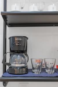 una cafetera y dos tazones en un estante en Cafofo Nice, en Río de Janeiro