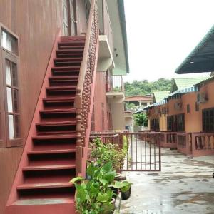 eine rote Treppe an der Seite eines Gebäudes in der Unterkunft Nipahmas Chalet in Pulau Pangkor