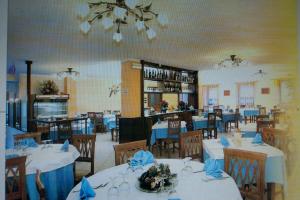 un comedor con mesas y sillas con servilletas azules en Hotel Ristorante Ligure, en Vinadio