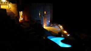 a swimming pool in front of a castle at night at Auberge Le Festival Todra Gorge in Aït Baha