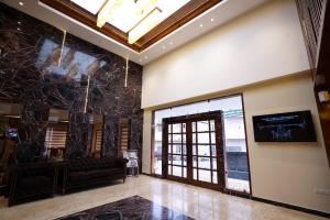 a lobby with a couch and a large glass door at Hotel Indo Prime in Jaipur