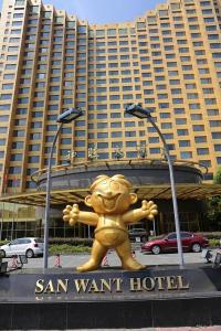 una gran estatua de oso amarillo delante de un edificio en San Want Hotel Shanghai en Shanghái