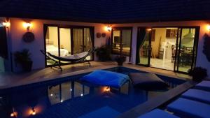a villa with a swimming pool at night at Spacious ocean view pool villa in Koh Samui 
