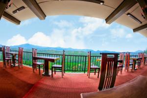 a balcony with tables and chairs and a view of mountains at Romance Hills Hotel in Kandy