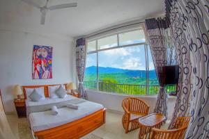 a bedroom with a bed and a large window at Romance Hills Hotel in Kandy