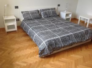a bed with a black and white plaid blanket at Bologna Center Town in Bologna