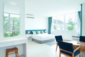 a room with a bed, chair and a window at Cove 55 in Santubong