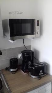 a kitchen counter with a microwave and a coffee maker at perle rare à énergie positive in Saint-Michel-Chef-Chef