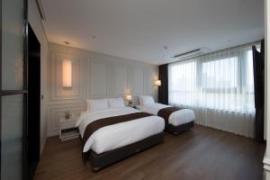 2 letti in una camera d'albergo con finestre di Ramada by Wyndham Daejeon a Daejeon