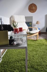 sala de estar con mesa y alfombra verde en Chambre équipée avec entrée indépendante, en La Chapelle-Thouarault