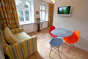 a living room with a couch and a table and chairs at Crystal Suites Chez Helena in Kraków