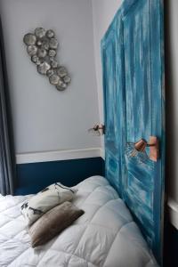 a bedroom with a blue headboard and a bed at Charmant Studio au calme à 5 min du centre ville in Saint-Claude