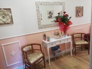 una habitación con 2 sillas y una mesa con flores en Il Sorriso, en Florencia