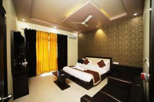 a bedroom with a bed and a chair in a room at Hotel Pushkar Legacy in Pushkar