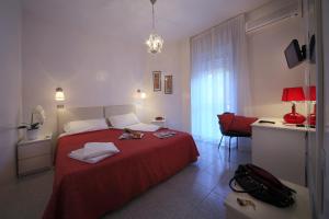 a hotel room with a red bed and a desk at Hotel Cristallo Brescia in Brescia