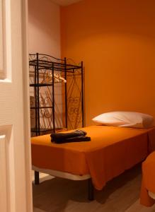 - une chambre dotée d'un lit avec un mur orange dans l'établissement Colors Rooms, à Valence