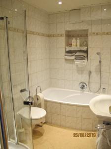 a bathroom with a tub and a toilet and a sink at Gästezimmer 1 mit Bad in Angersbach