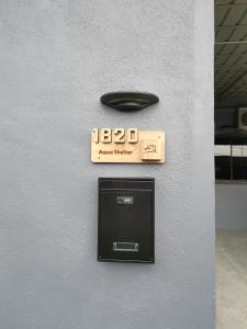 a sign on the side of a wall with a box at Aqua Shelter in Mersing