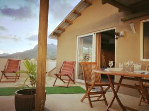 eine Terrasse mit Stühlen und einem Tisch mit Aussicht in der Unterkunft Le Morne Kite Villas - Penthouse in La Gaulette