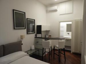 um quarto com uma cama, uma mesa e cadeiras em Luca Giordano 142 B&B em Nápoles