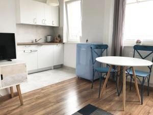 a kitchen with a table and chairs and a table and a table and a kitchen at Apartament Zaciszny in Gdańsk