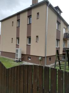 a building with a fence in front of it at Apartmany Agatha in Loučná nad Desnou