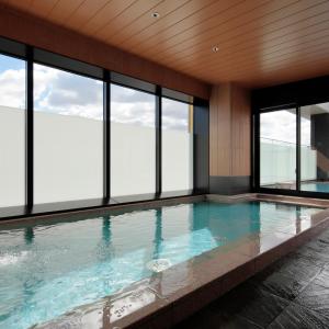 a swimming pool with windows in a building at Candeo Hotels Osaka Kishibe in Suita