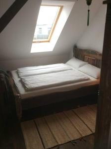 a small bed in a attic with a window at Helle Dachgeschosswohnung für 8 Personen in zentraler Lage in Berlin