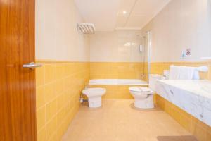 
a bathroom with a toilet a sink and a bath tub at Hotel Playa Mondrago in Portopetro

