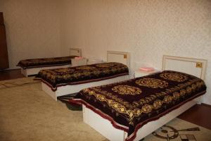 a room with three beds in a room at YOKUB Guest House in Samarkand