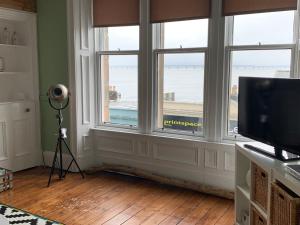 um quarto com janelas, uma televisão e uma câmara em Bridge View Apt - stunning River Tay views em Fife
