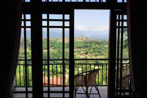 Zimmer mit einem Fenster mit einem Stuhl auf dem Balkon in der Unterkunft Serenity Hill Oasis in Kandy