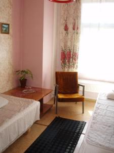 een slaapkamer met een stoel, een tafel en een raam bij Anna Bed & Breakfast in Kallaste