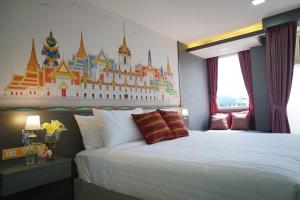 a bedroom with a large bed with a castle mural on the wall at The Qube fifty Hotel in Bangkok