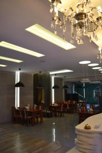 a dining room with tables and chairs and chandeliers at Hotel Julian in Szczecin