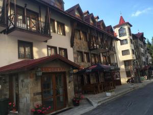 a building with tables and umbrellas on a street at Apartment 507 The Castle 1 in Pamporovo